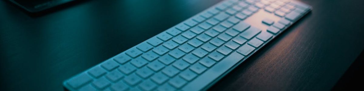 A modern wireless keyboard placed on a sleek desk, illuminated by ambient lighting in a tech-savvy office setting.